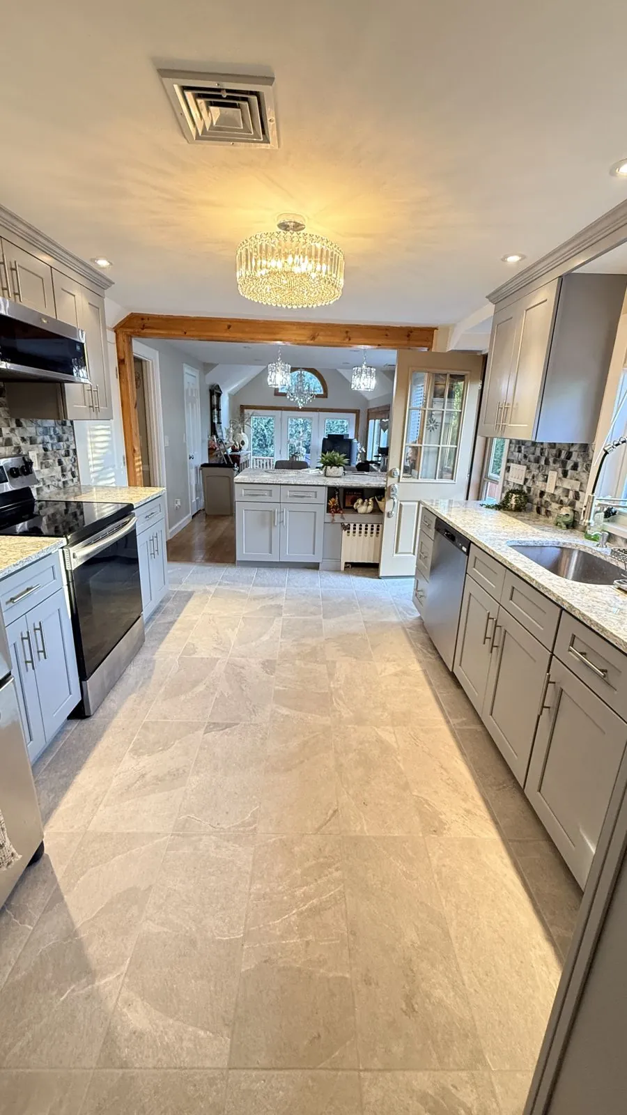Gray shaker cabinets, granite counters & chandelier
