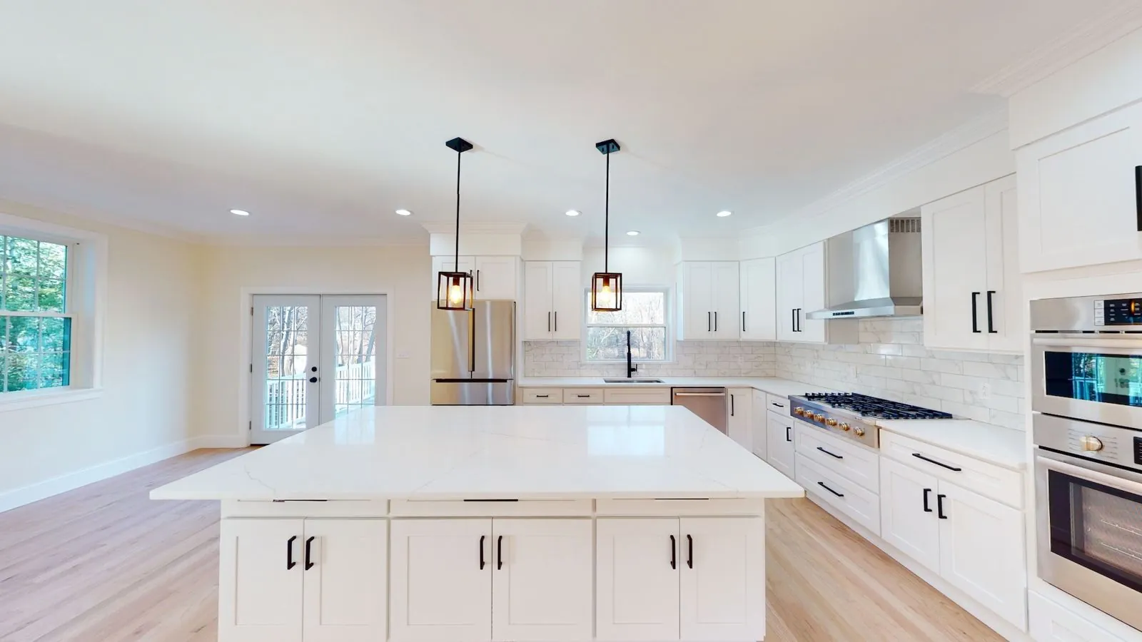 Kitchen remodel with white shaker cabinetry and quartz island